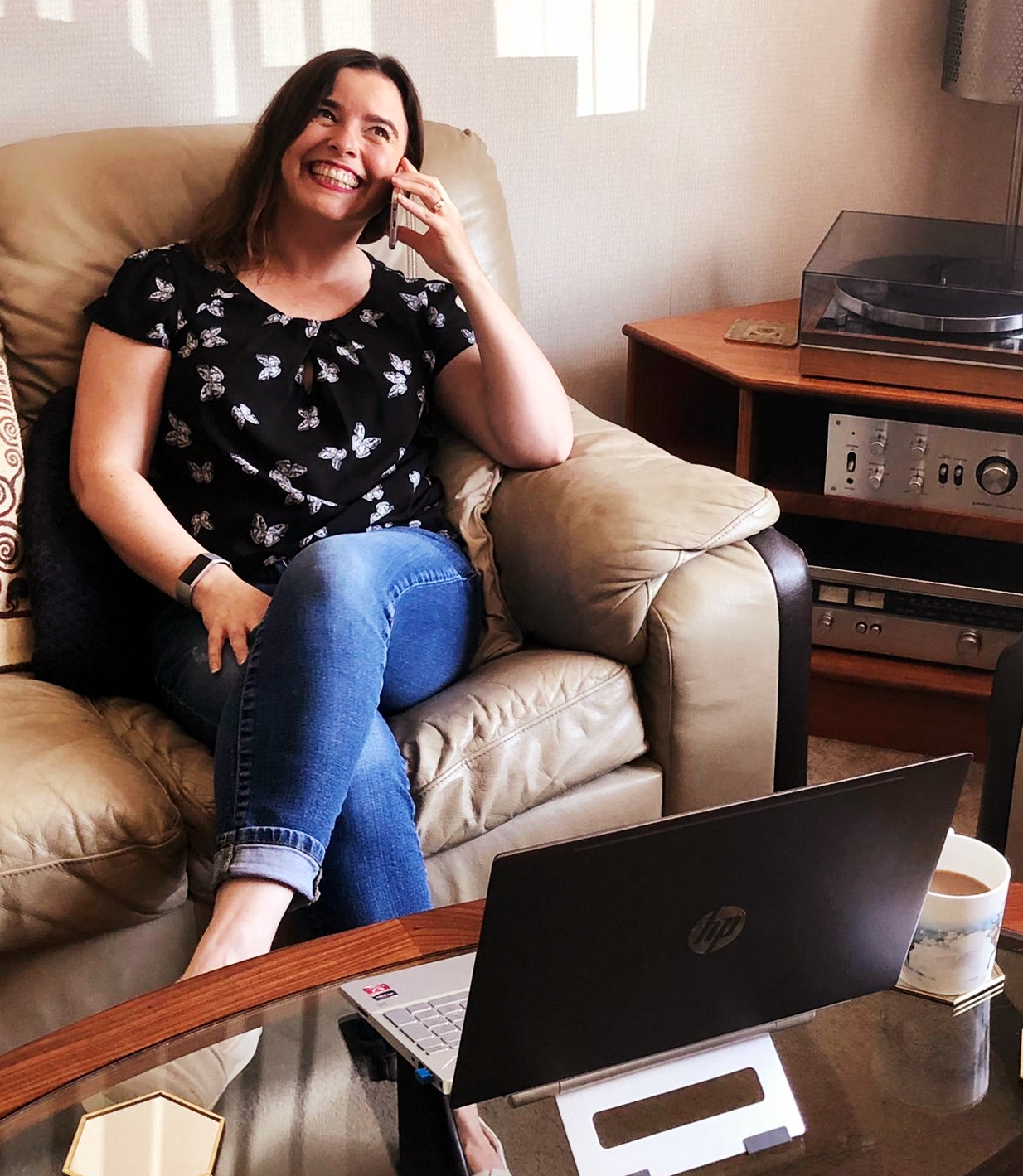 Frannie sitting on the sofa, smiling and speaking French on the phone