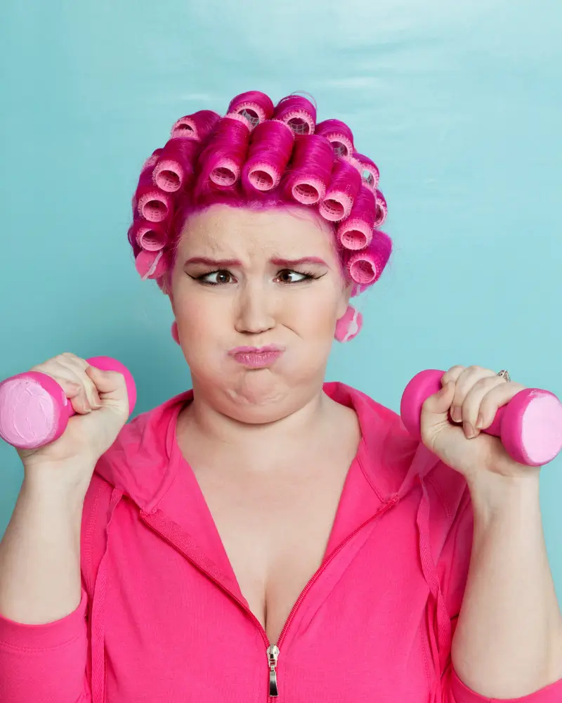 lady dressed in pink struggling with exercises and pulling a funny face