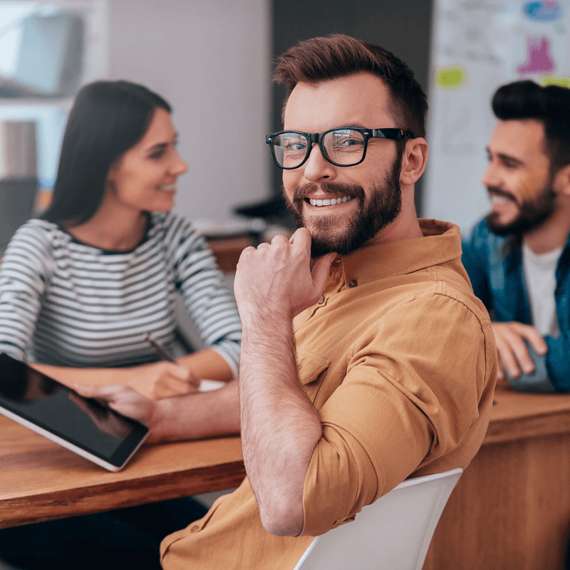 confident man with beard and glasses smiling at the camera