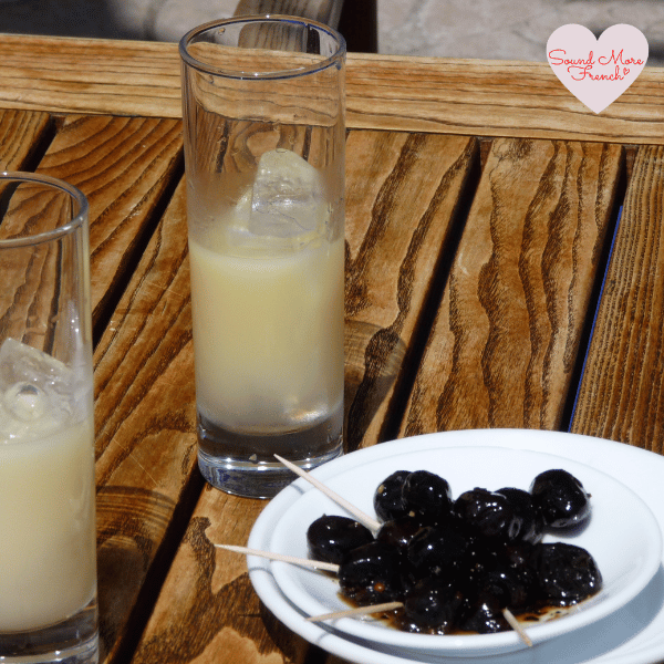 2 Two glasses of chilled pastis with ice and a plate of black olives – a classic southern French aperitif enjoyed outdoors with friends.