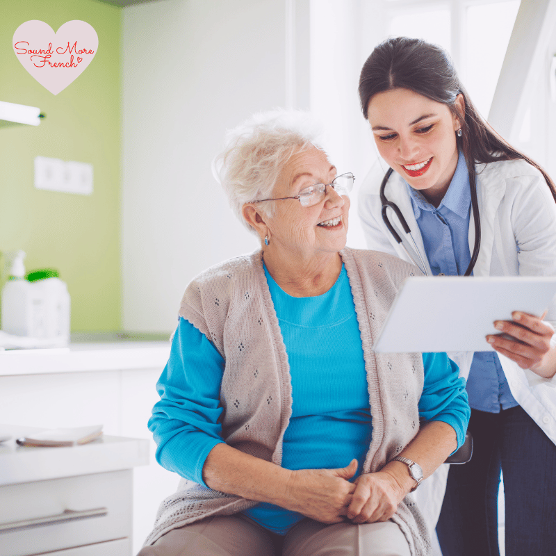 3 A doctor showing a cheerful older woman information on a tablet during a medical appointment.