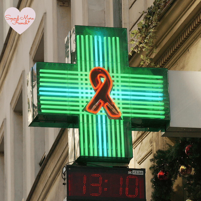 4 A bright green neon cross with a red symbol, commonly found outside French pharmacies.