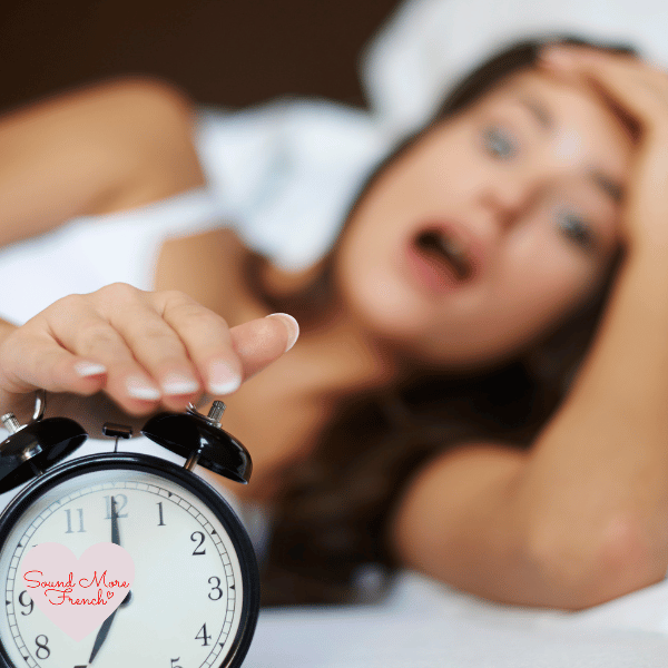 woman_in_bed_reaching_for_alarm_clock_with_shocked_expression