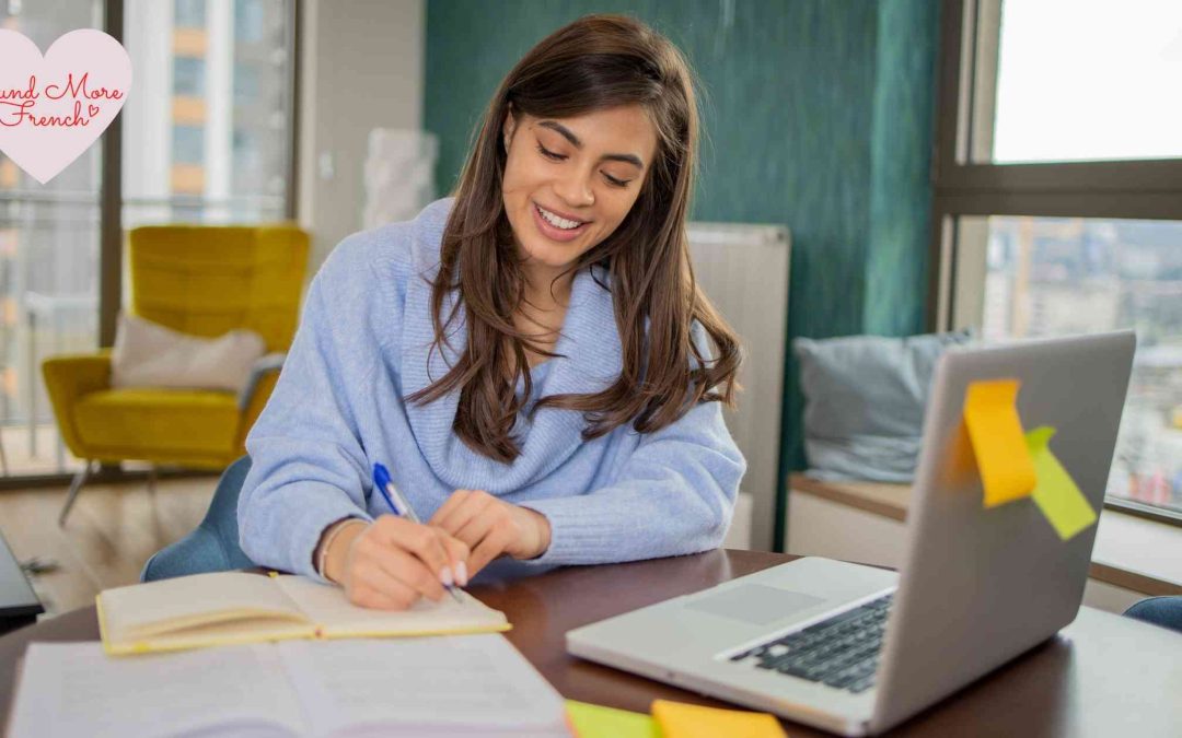 woman_writing_in_notebook_smiling_studying_at_home_with_laptop_yellow_chair_in_background_sound_more_french_logo_in_corner