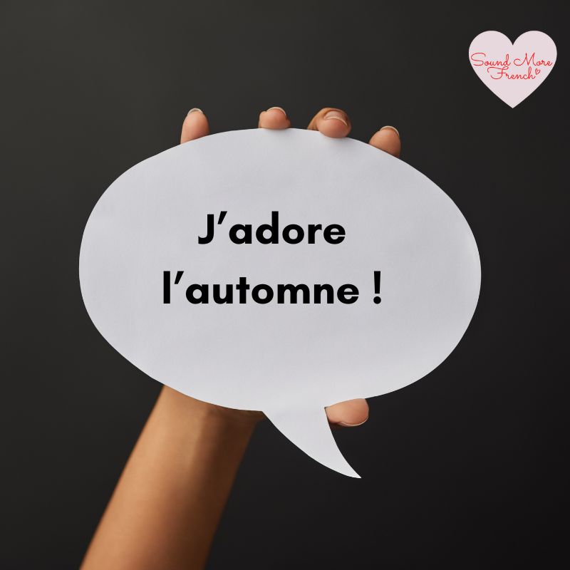 hand_holding_speech_bubble_with_text_jadore_lautomne_on_black_background_sound_more_french_logo