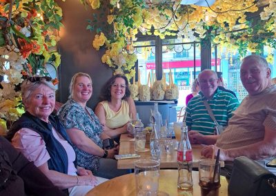 Café_Cats_in_Paris_relaxing_together_in_a_flower-decorated_Parisian_café_with_drinks_and_smiles