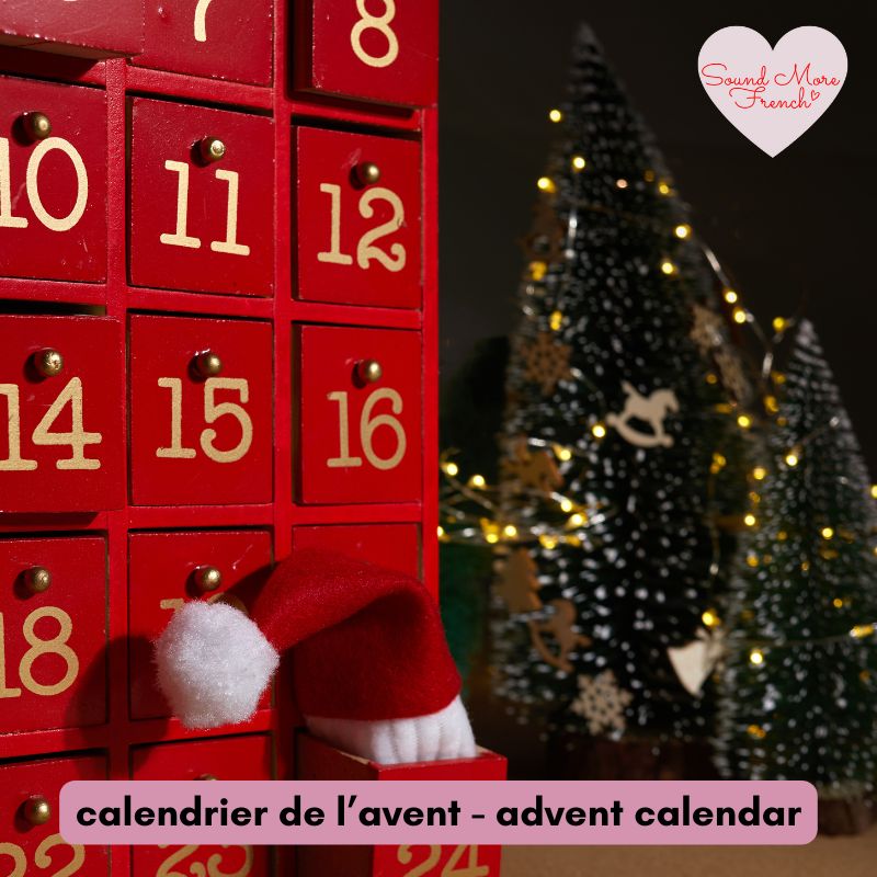 red_advent_calendar_with_small_drawers_and_santa_hat_next_to_christmas_trees_with_fairy_lights_with_french_and_english_vocab_label