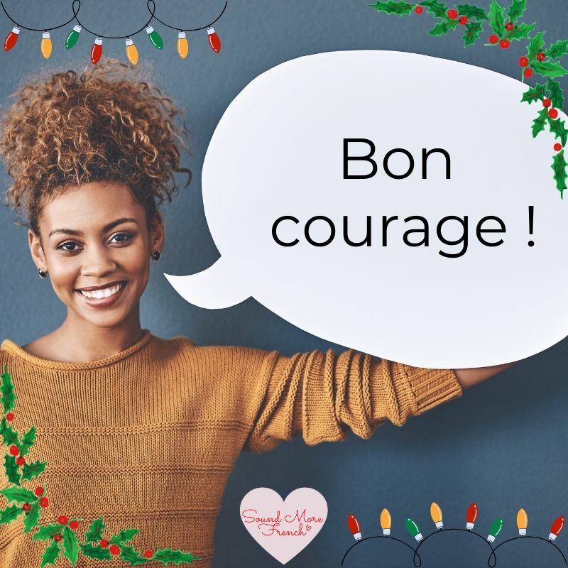 smiling_woman_holding_speech_bubble_with_text_bon_courage_surrounded_by_christmas_lights_and_holly_sound_more_french_logo_visible