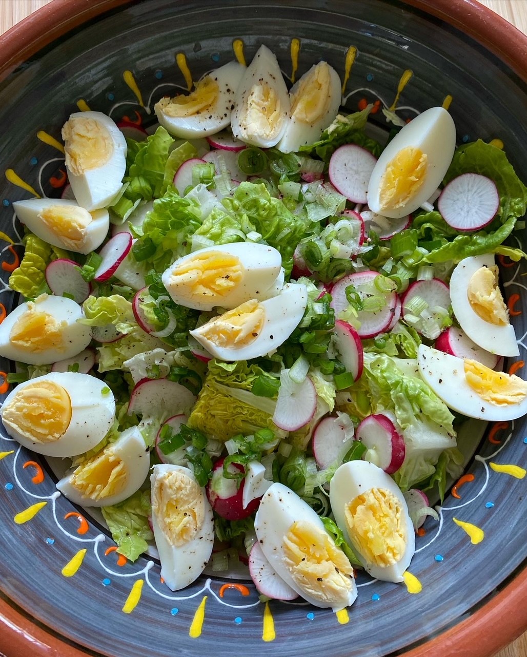 French Easter food salade pascale with hard boiled eggs radishes and spring onions in a decorative bowl